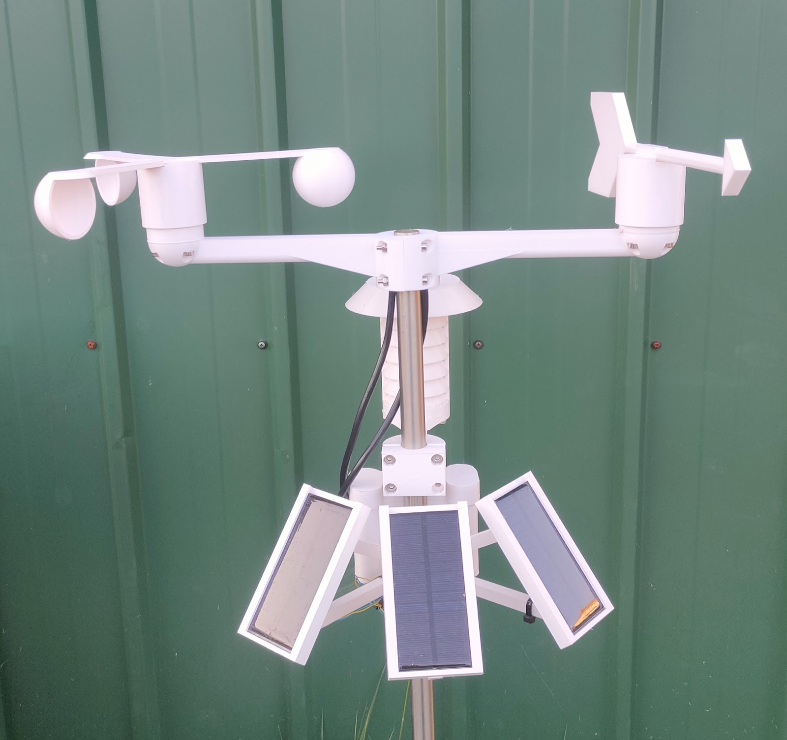 Solar-powered weather station with anemometer, wind vane, sensors, and solar panels